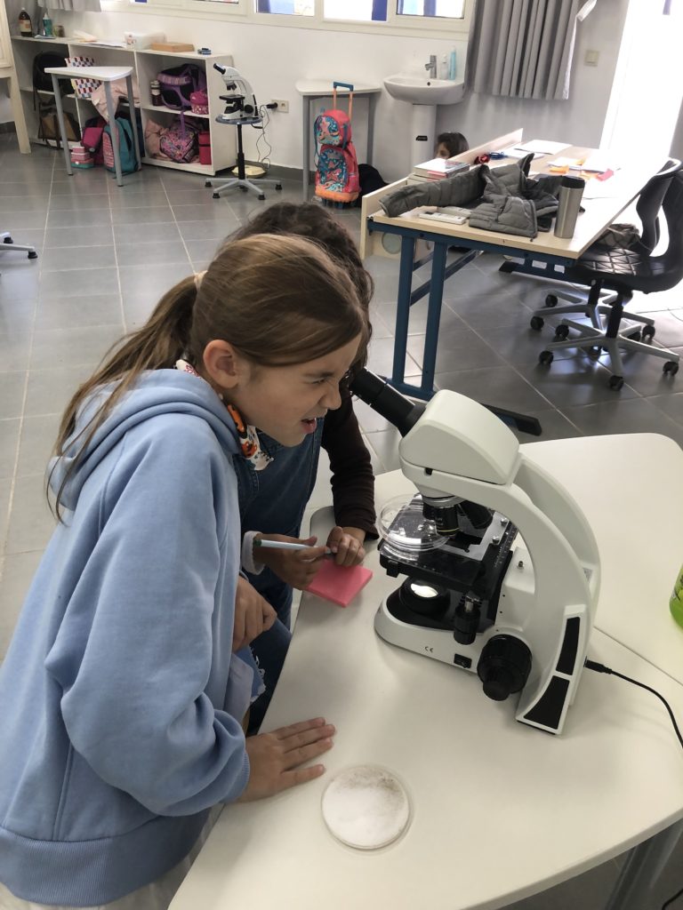 Girl looks into microscope