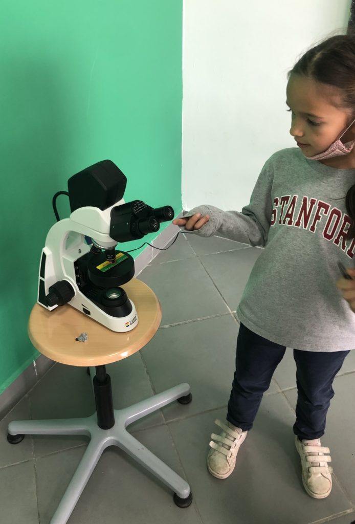 Girl pointing at microscope